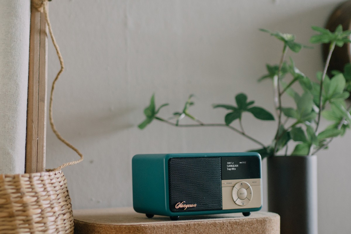 Radio verte posée près d'un panier et d'une plante d'intérieur