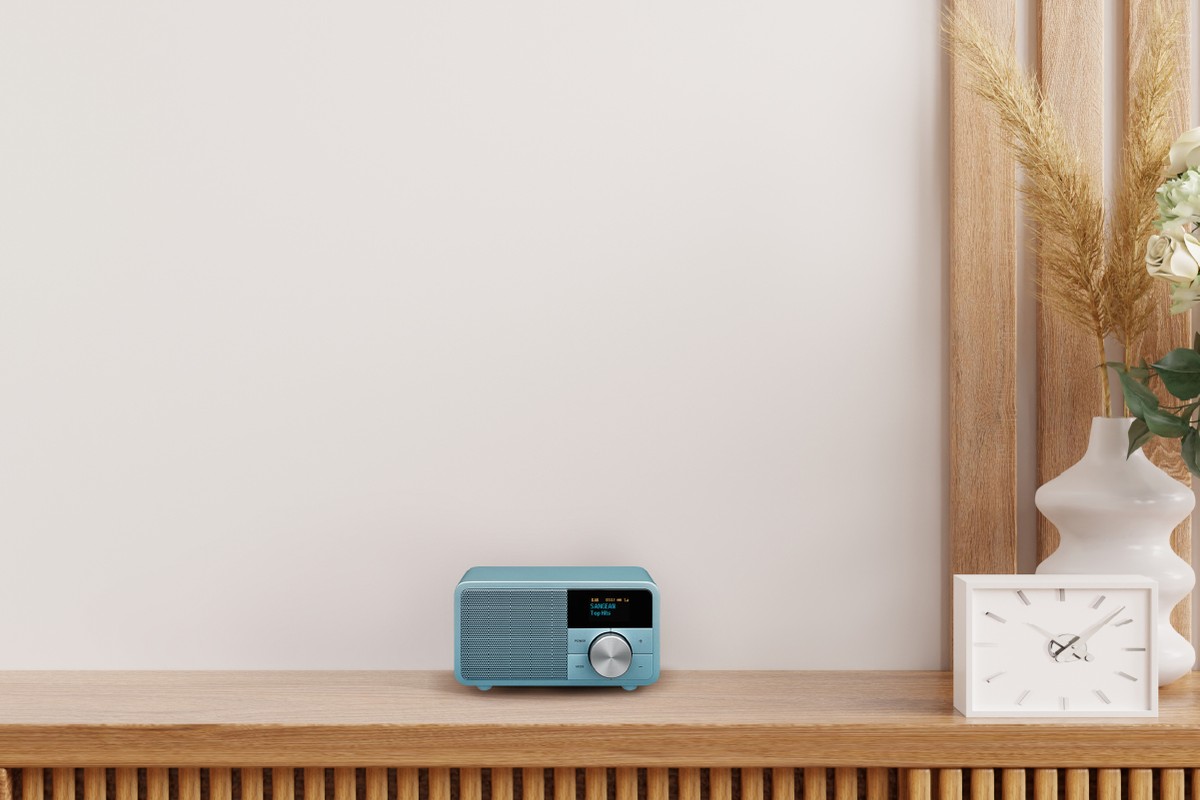 Radio Sangean bleue sur une console en bois cannelé