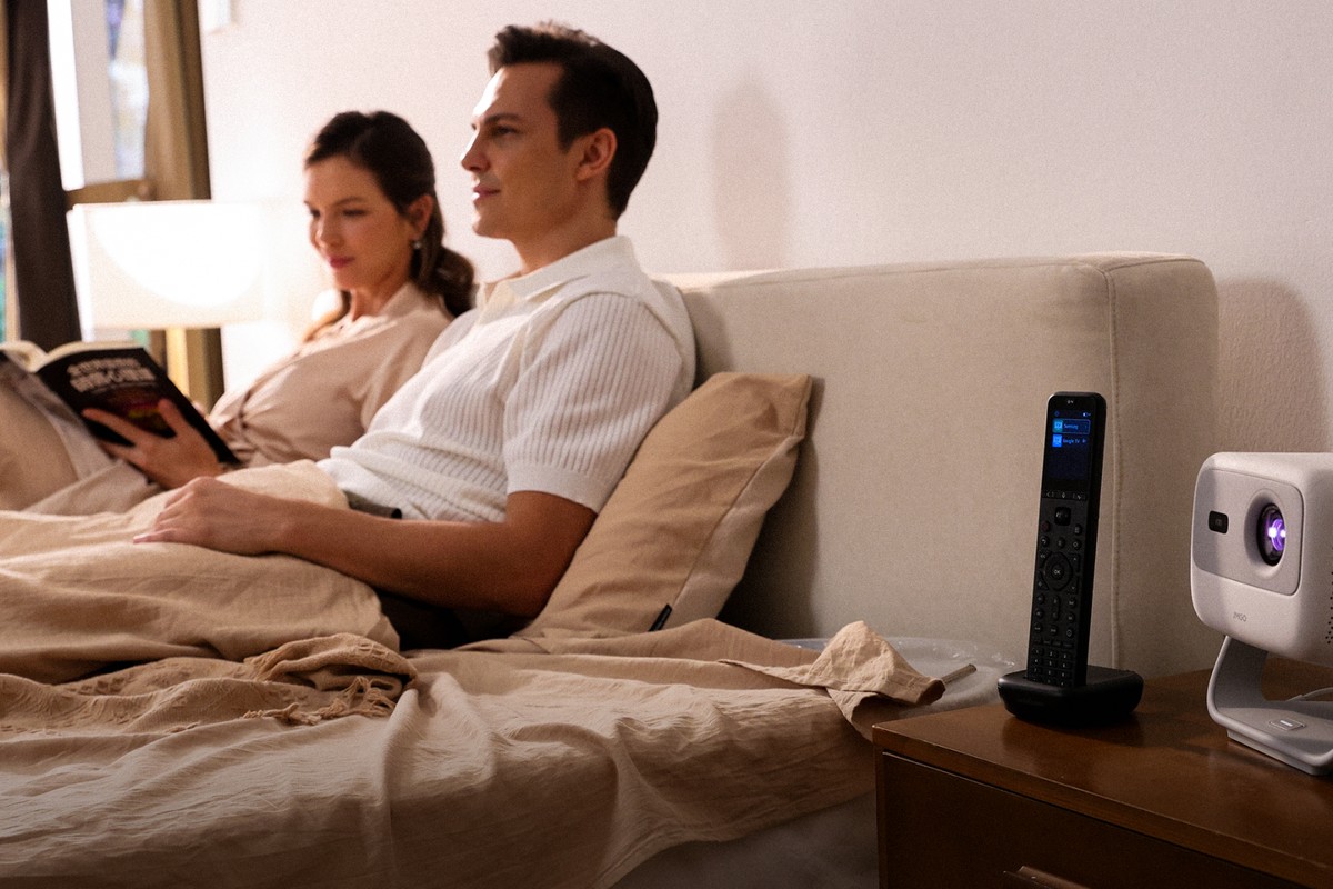 Remote sitting in its charging dock on a bedside table