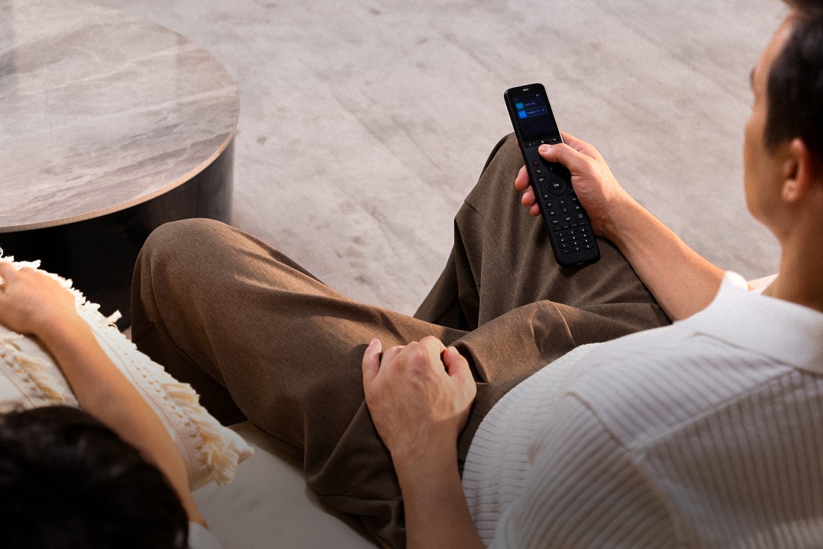 Overhead view of a living room, remote screen lit