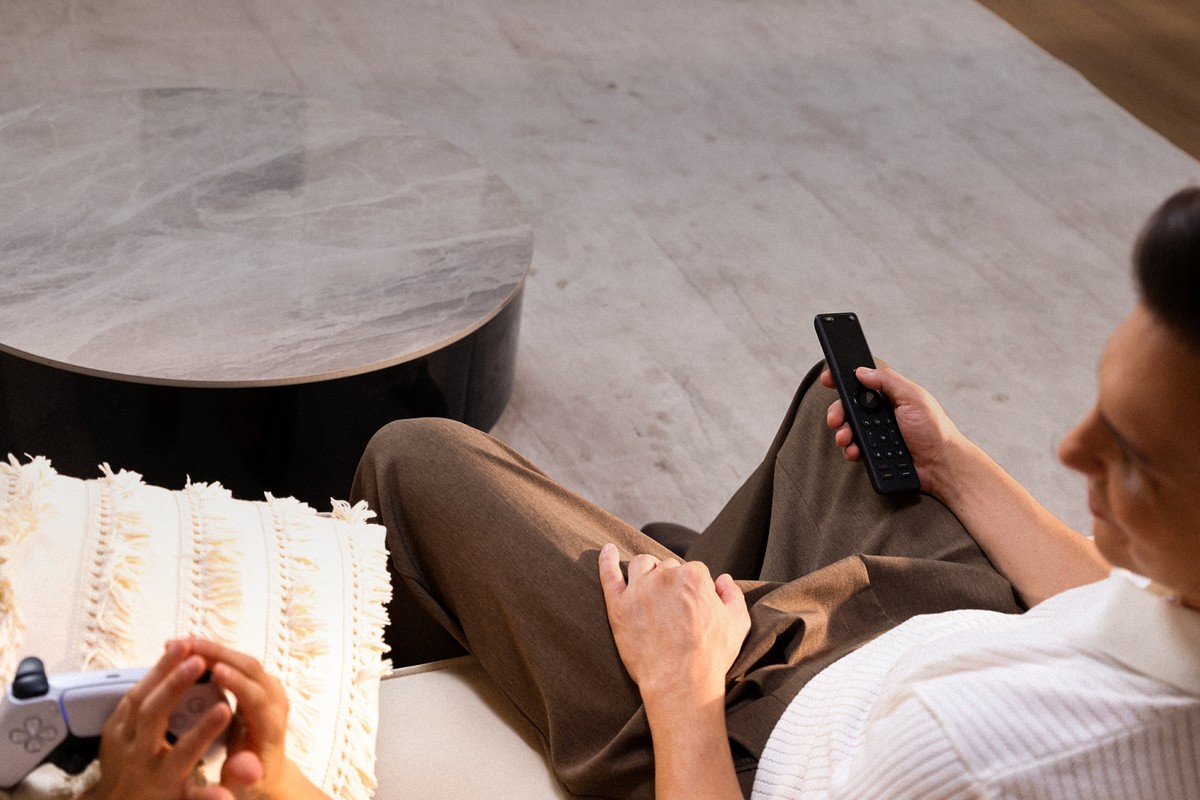Man on a sofa, SofaBaton X1S remote in his hand