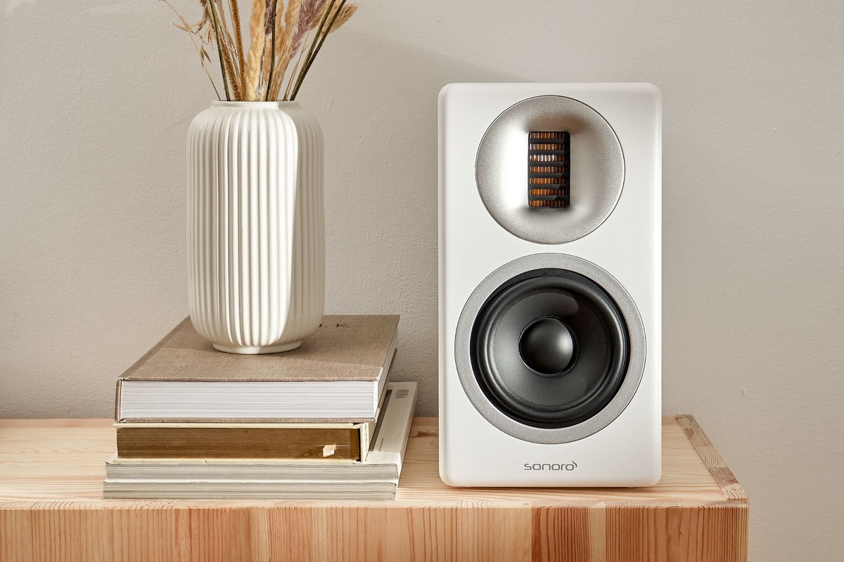 Matt white speaker standing on a stack of books