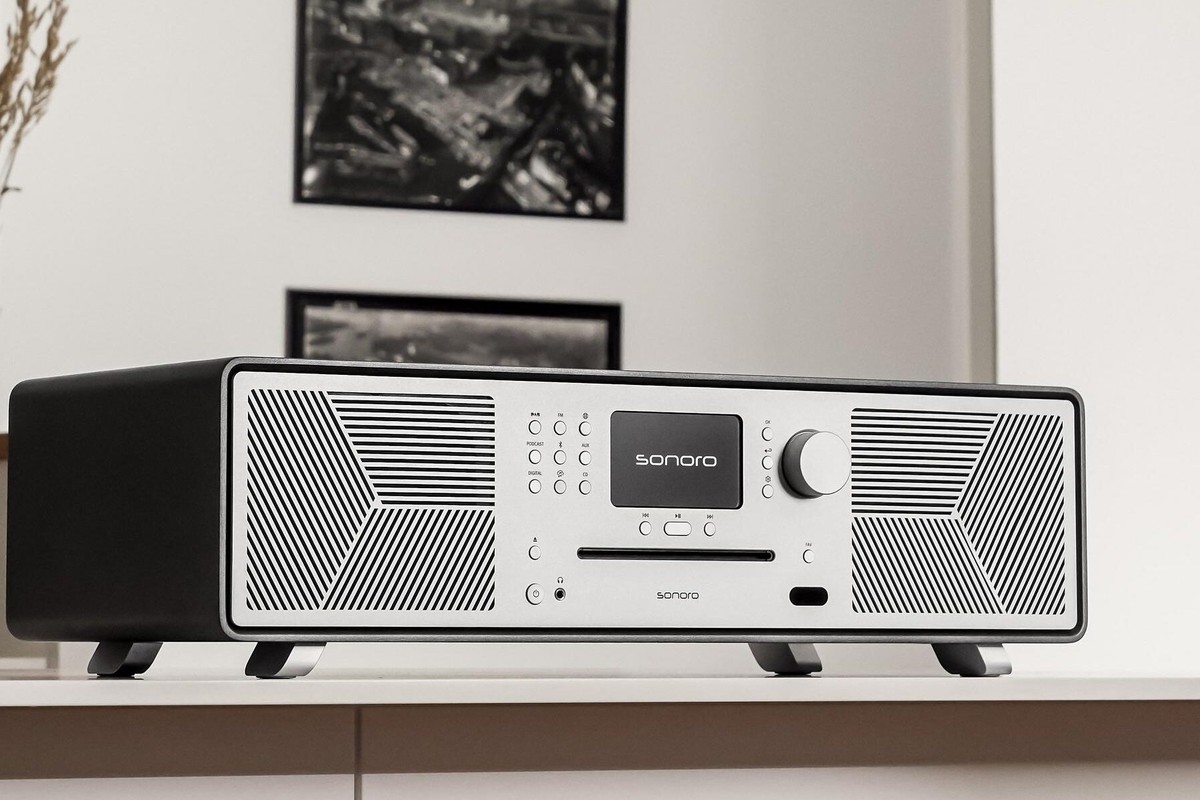 Audio system with a black cabinet and silver front on a low unit, in a bright living room