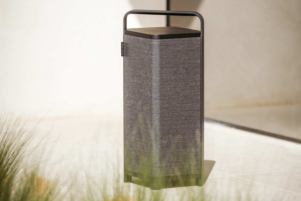 Sonoro VIBES L noire posée sur un sol clair, entourée d'herbes hautes