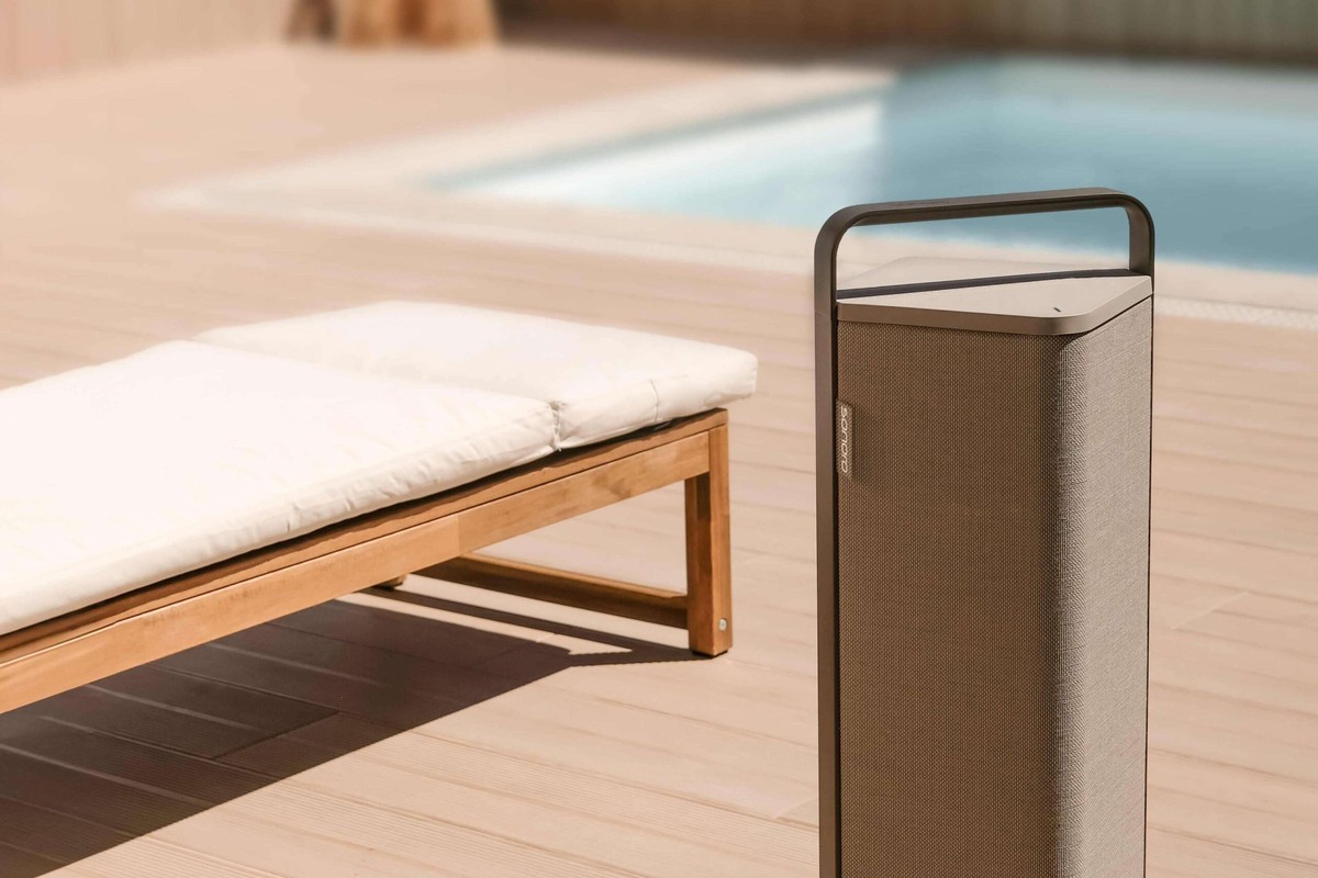 Sonoro VIBES XL beige accanto a una sdraio, piscina sullo sfondo