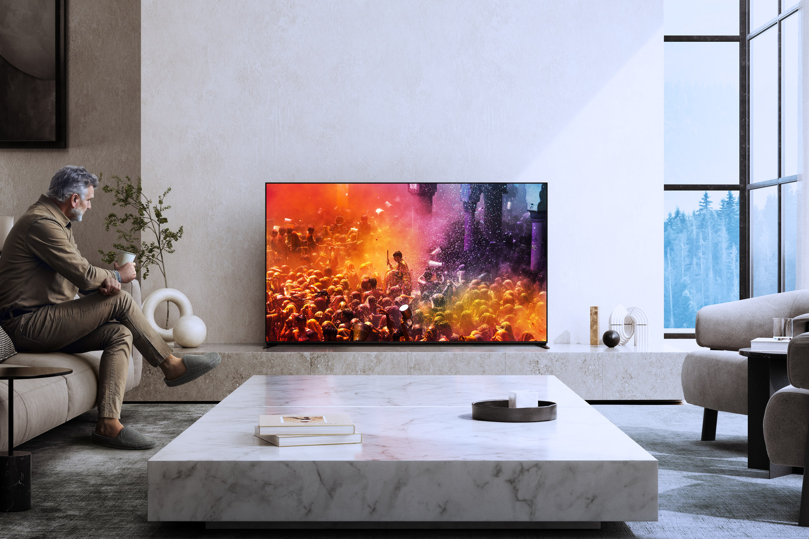 A man seated in front of the Sony BRAVIA 9 television