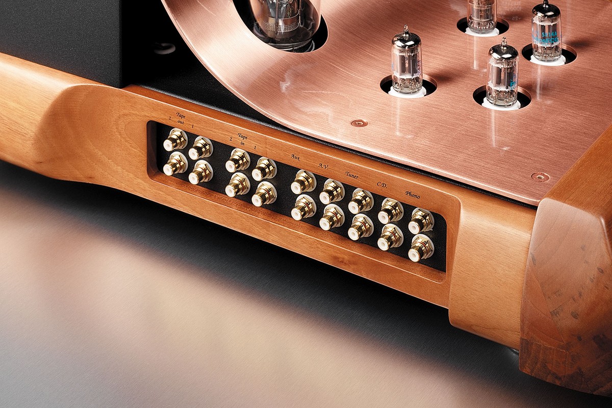 Row of gold-plated RCA sockets set into the wooden front, below a copper plate
