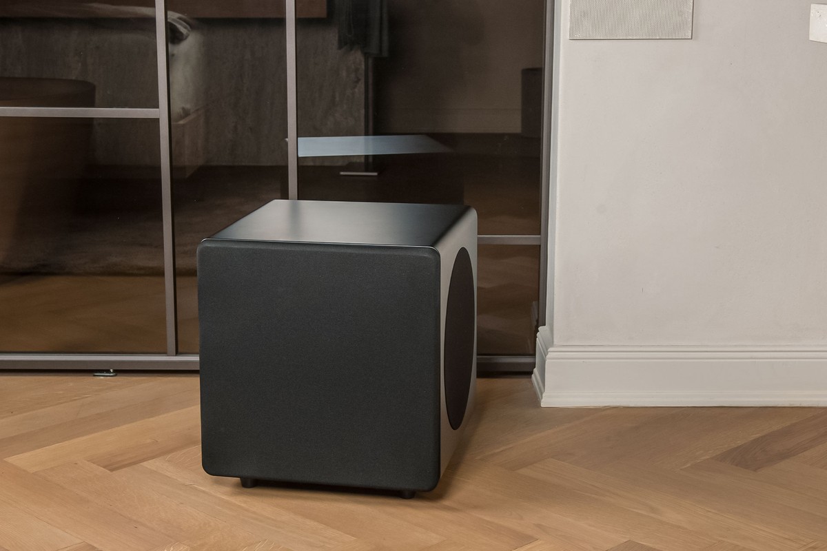 Caisson noir sur parquet, près d'un miroir