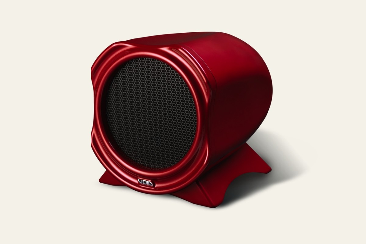 Caisson de basses Air 15 rouge à grille noire, vu de trois quarts sur fond crème