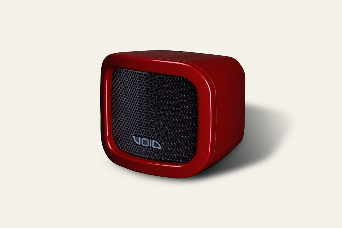 Face avant d'une enceinte compacte rouge avec sa grille noire et le logo Void