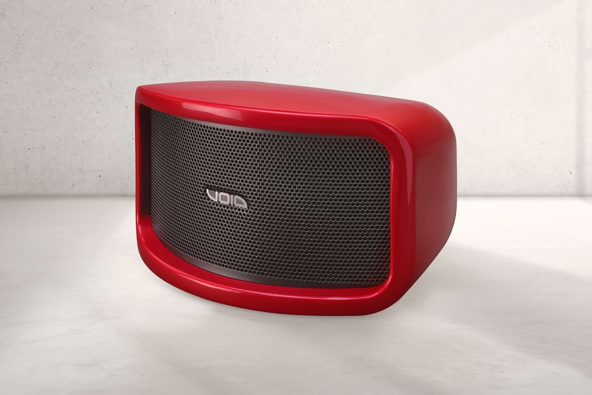 Enceinte Void Acoustics Cyclone 55 rouge à grille noire posée sur un sol de béton clair