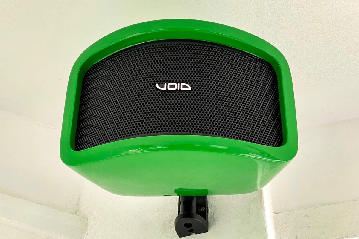 Enceinte en teinte verte sur mesure, montée sous un plafond sur son étrier