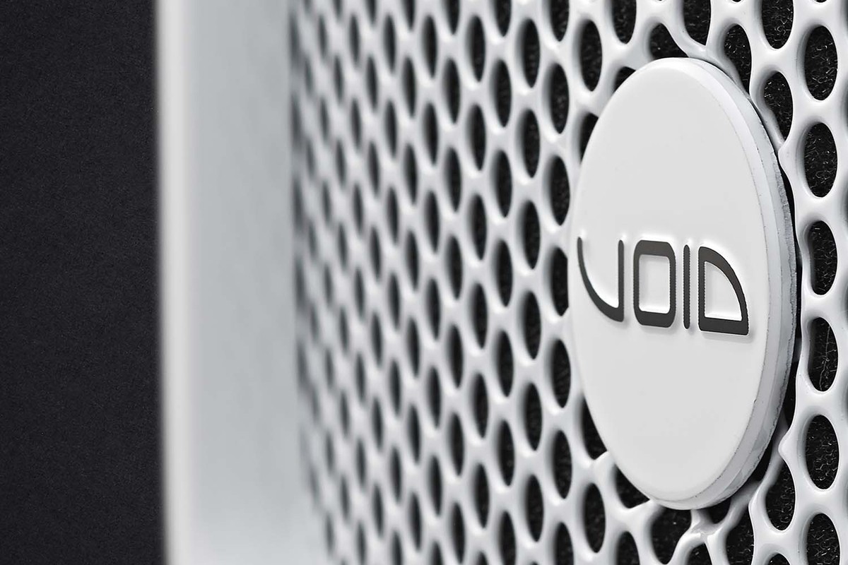 Gros plan sur la grille perforée blanche et le logo d'une enceinte
