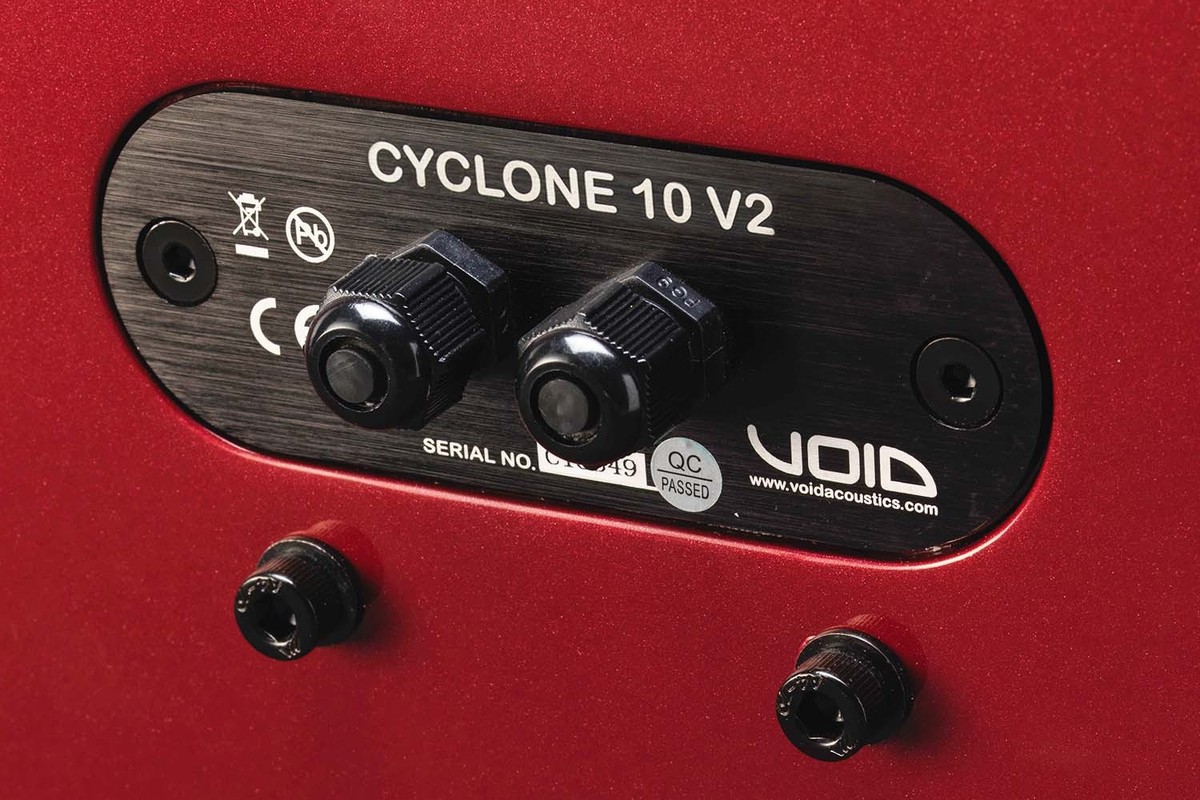 Plaque de connexion arrière d'une enceinte rouge avec ses deux presse-étoupes