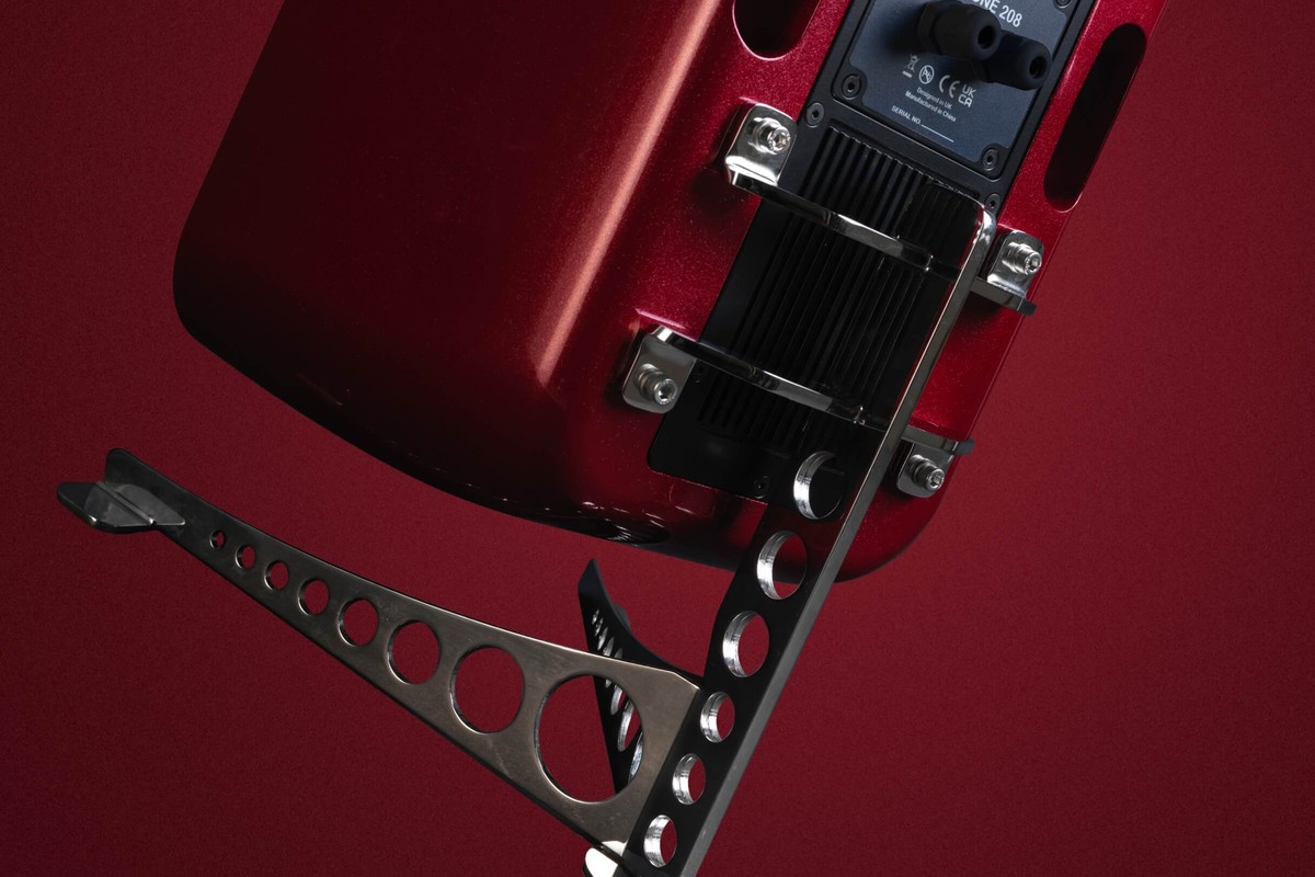 Face arrière d'un caisson de basses rouge avec sa plaque de raccordement et son étrier en acier