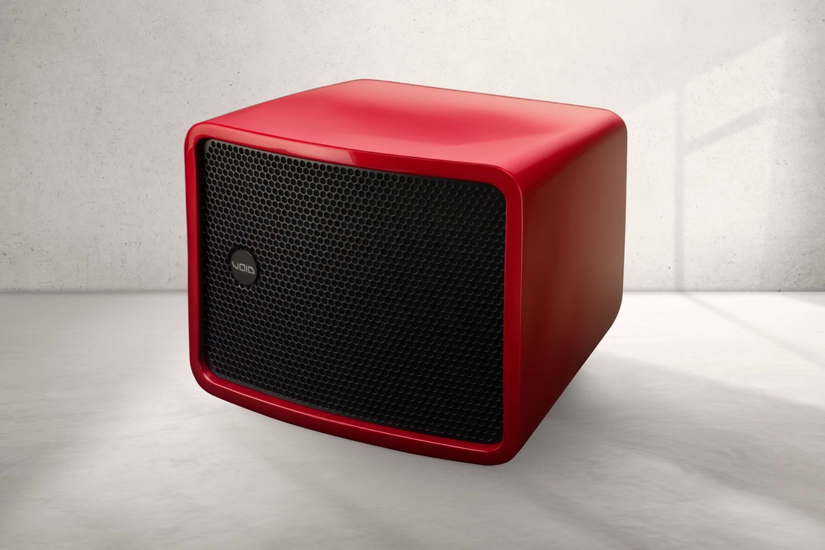 Caisson de basses Void Acoustics Cyclone Bass rouge à grille noire posé sur un sol clair