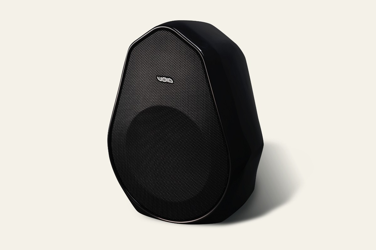 Caisson de basses Void Acoustics Indigo Sub noir, vue de trois quarts, grille perforée et logo, sur fond crème