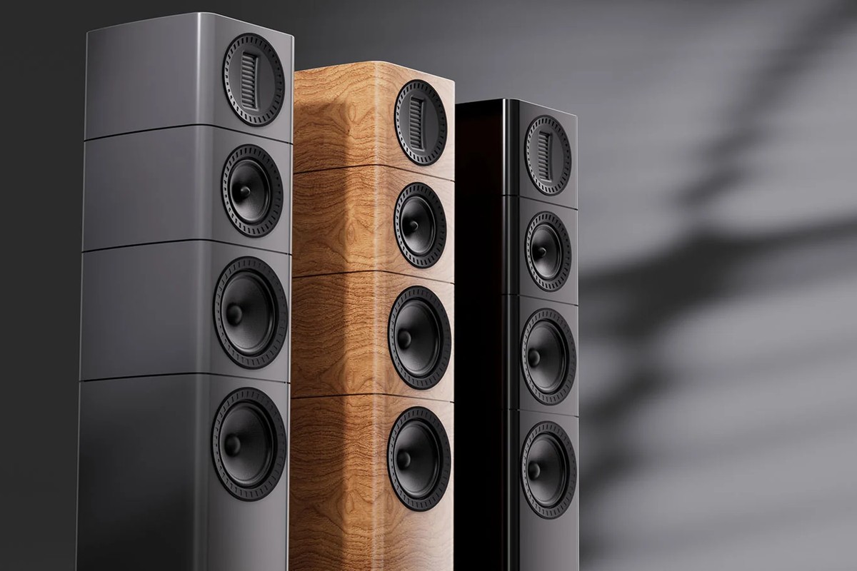 Close-up of three towers in grey, light walnut and black on a dark background