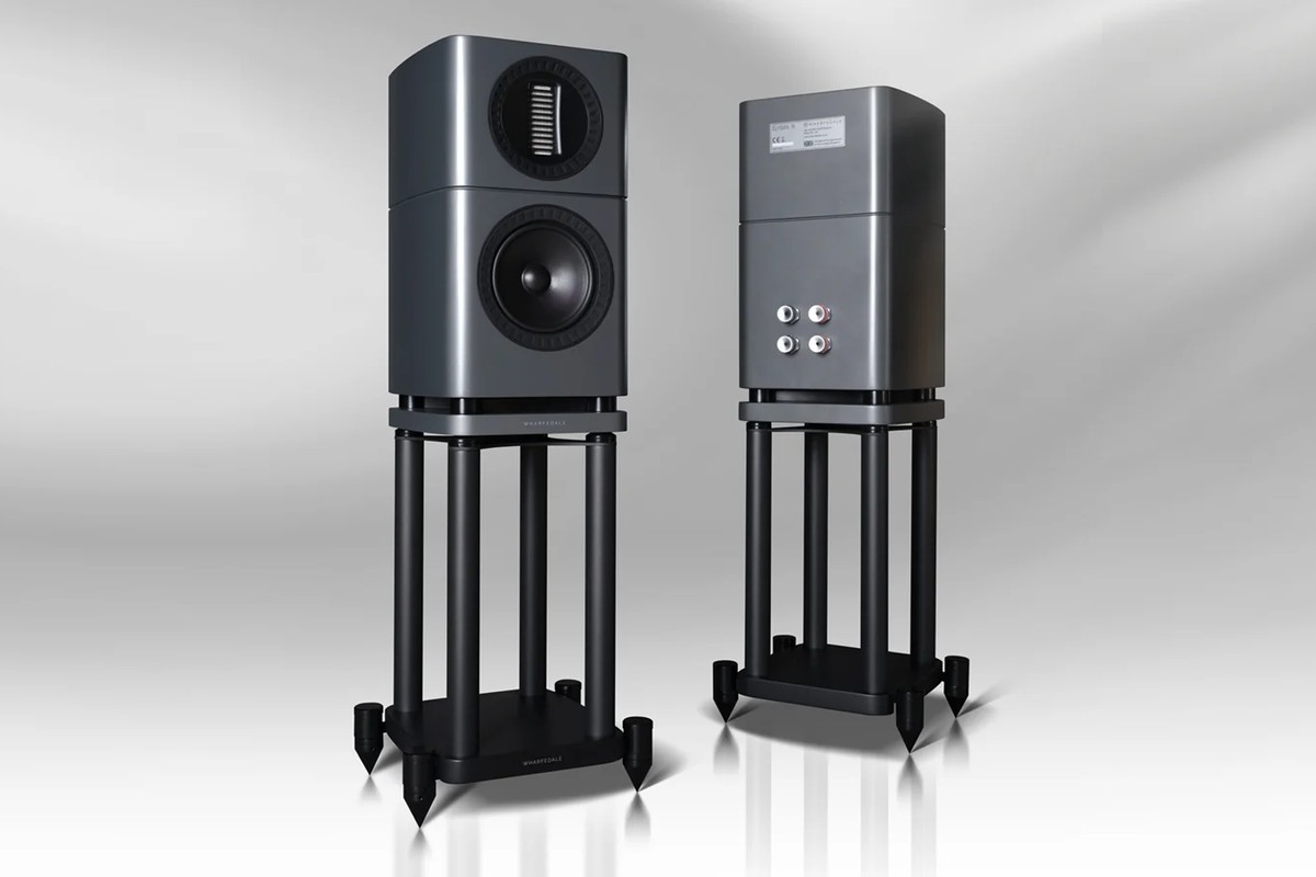 Two grey speakers on stands, one from the front and the other from behind with its four terminals