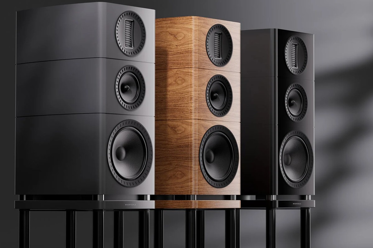 Three speakers in grey, light walnut and black on black stands