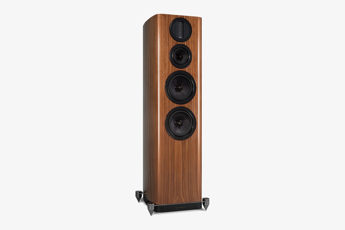 Walnut floorstanding speaker seen from three-quarter angle on its base