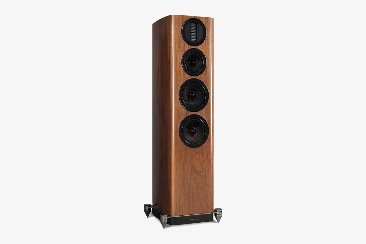 Walnut floorstanding speaker seen from three-quarter angle on its base