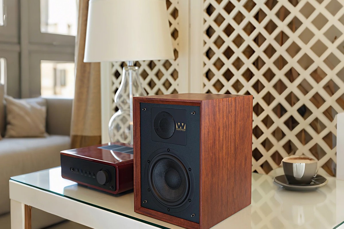Mahogany DENTON 85 speaker on a coffee table, next to an amplifier and a cup