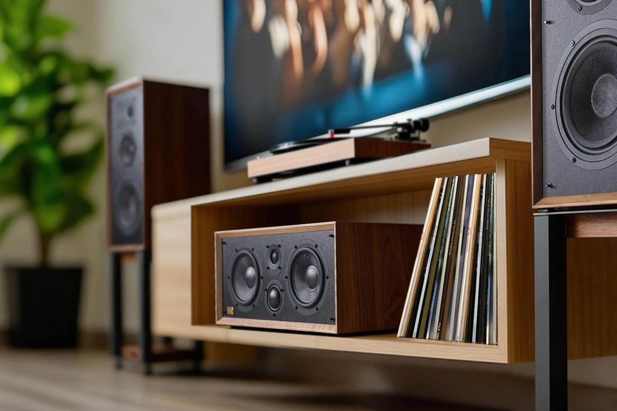 Centre speaker set into a wooden shelf, with vinyl records and a television above