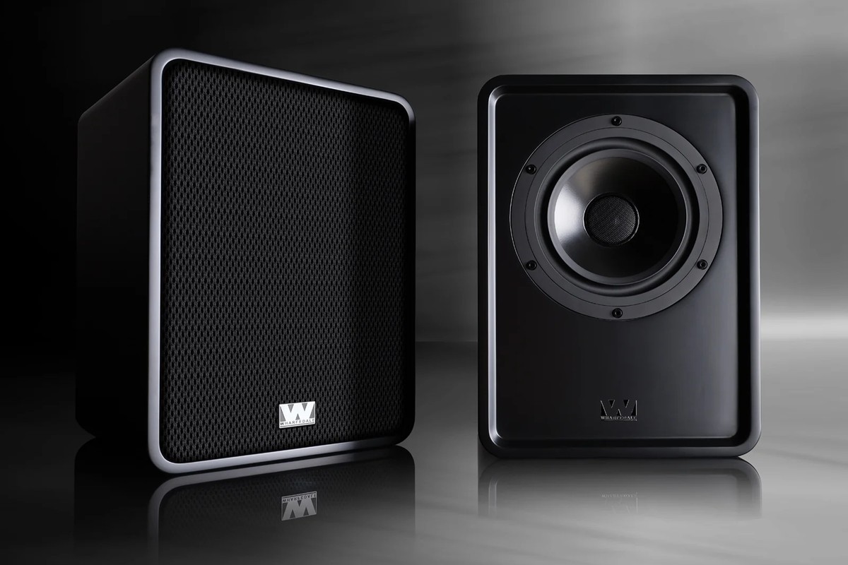 Two black speakers, one with its cloth grille, the other with its coaxial driver visible