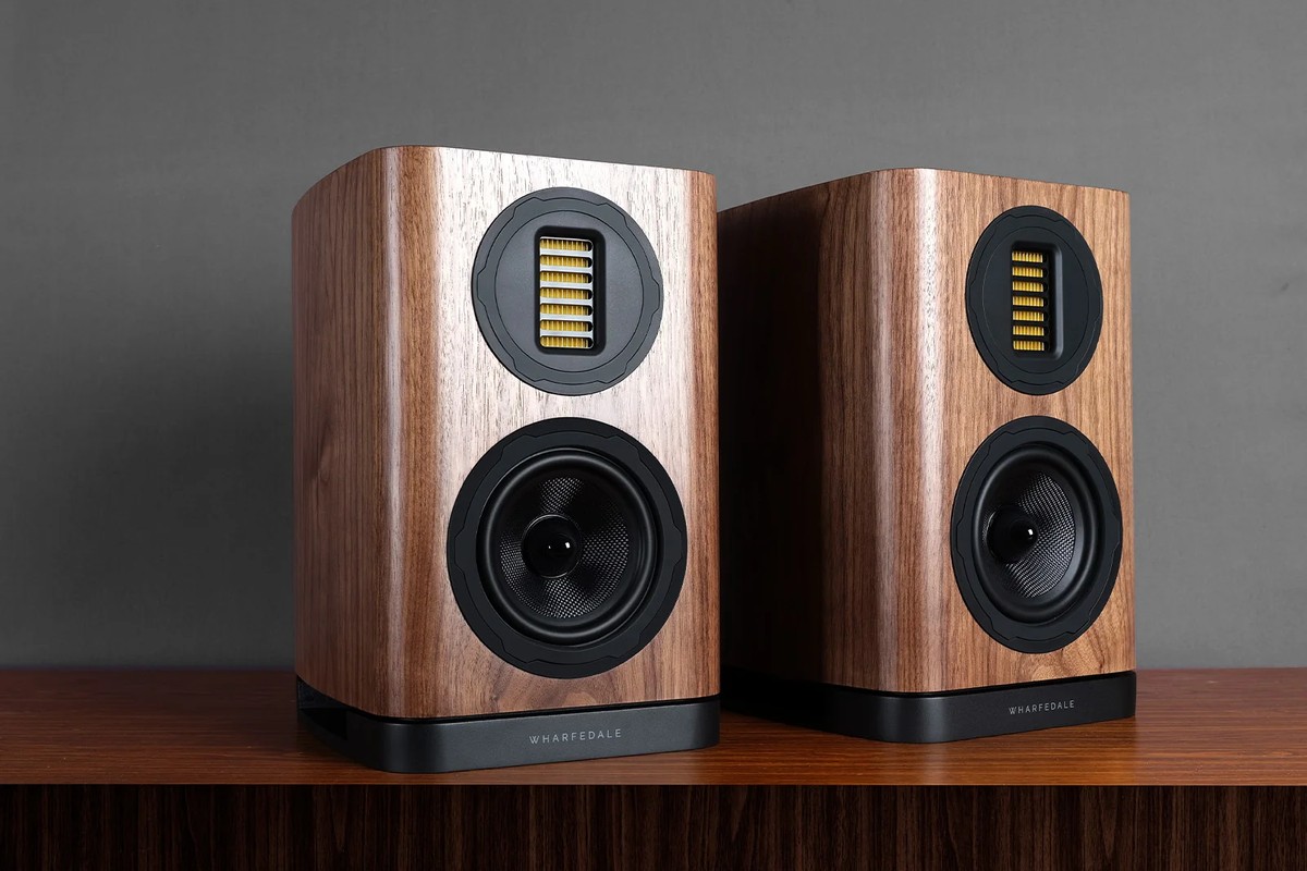 Two walnut bookshelf speakers on a cabinet, seen from the front