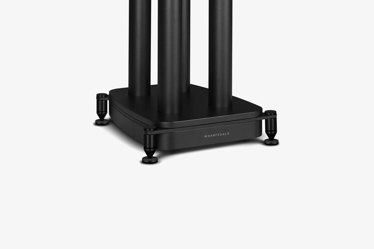 Black base of a speaker stand and its spikes seen at three-quarter angle