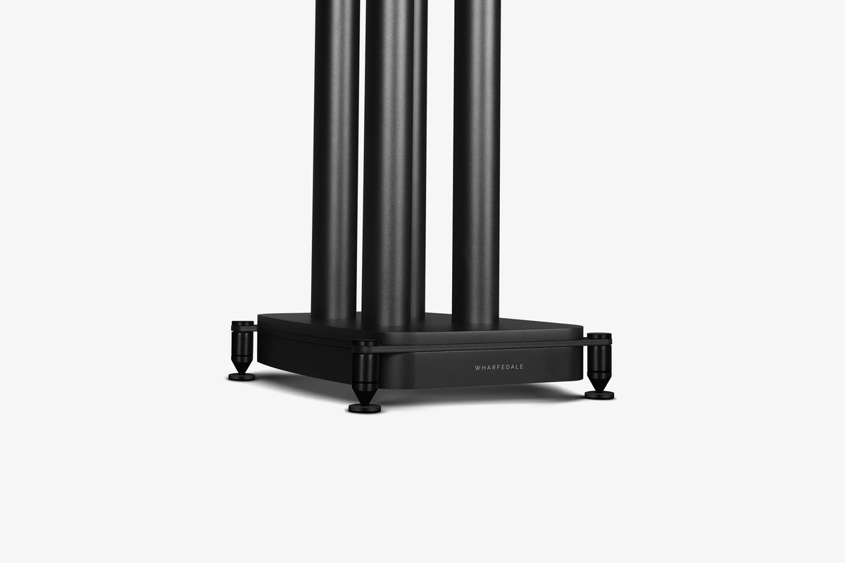 Black base of a speaker stand and its spikes seen at three-quarter angle