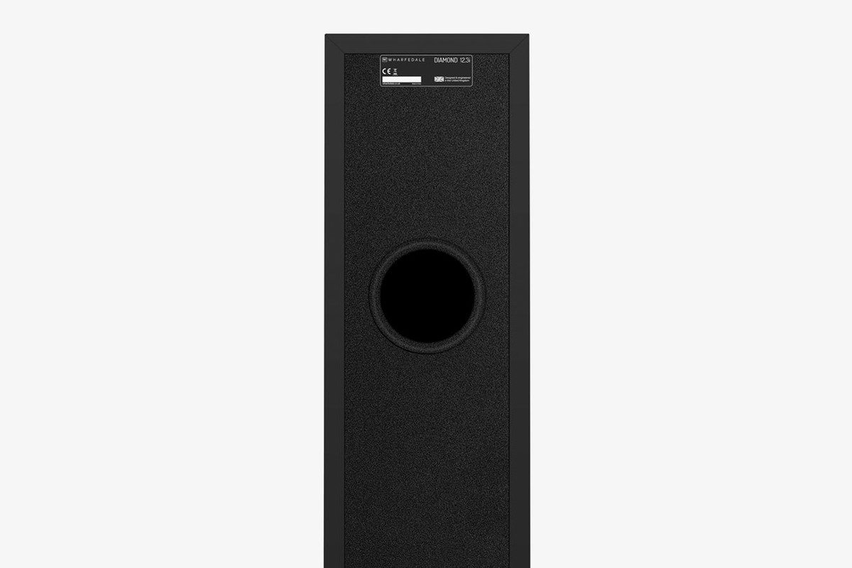 Back of a black speaker with its circular port and rating plate
