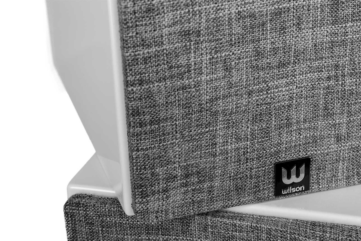 Close-up of two grey heathered-fabric grilles, black badge at the bottom of the grille