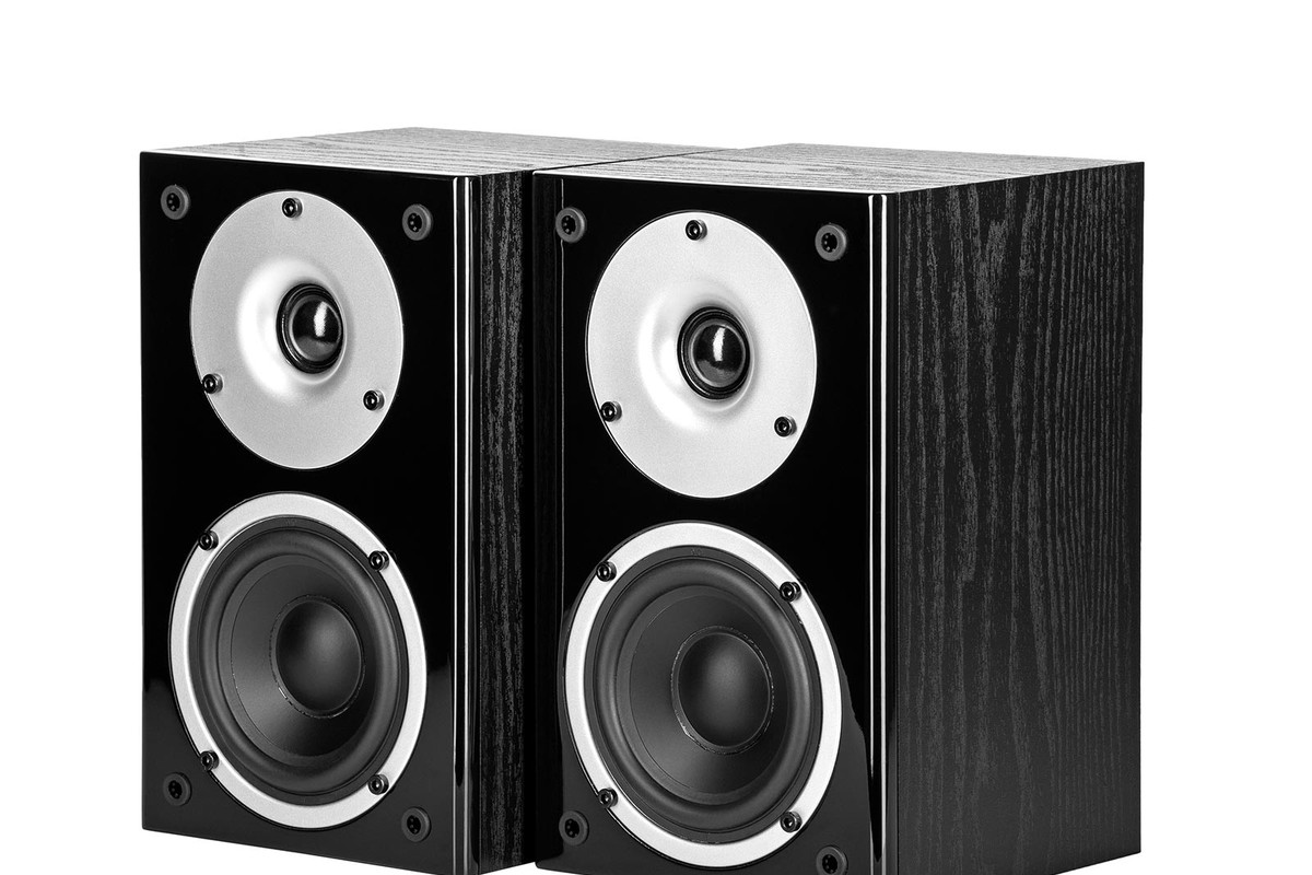 Pair of black bookshelf speakers seen from three quarters, dome and mid-range driver visible