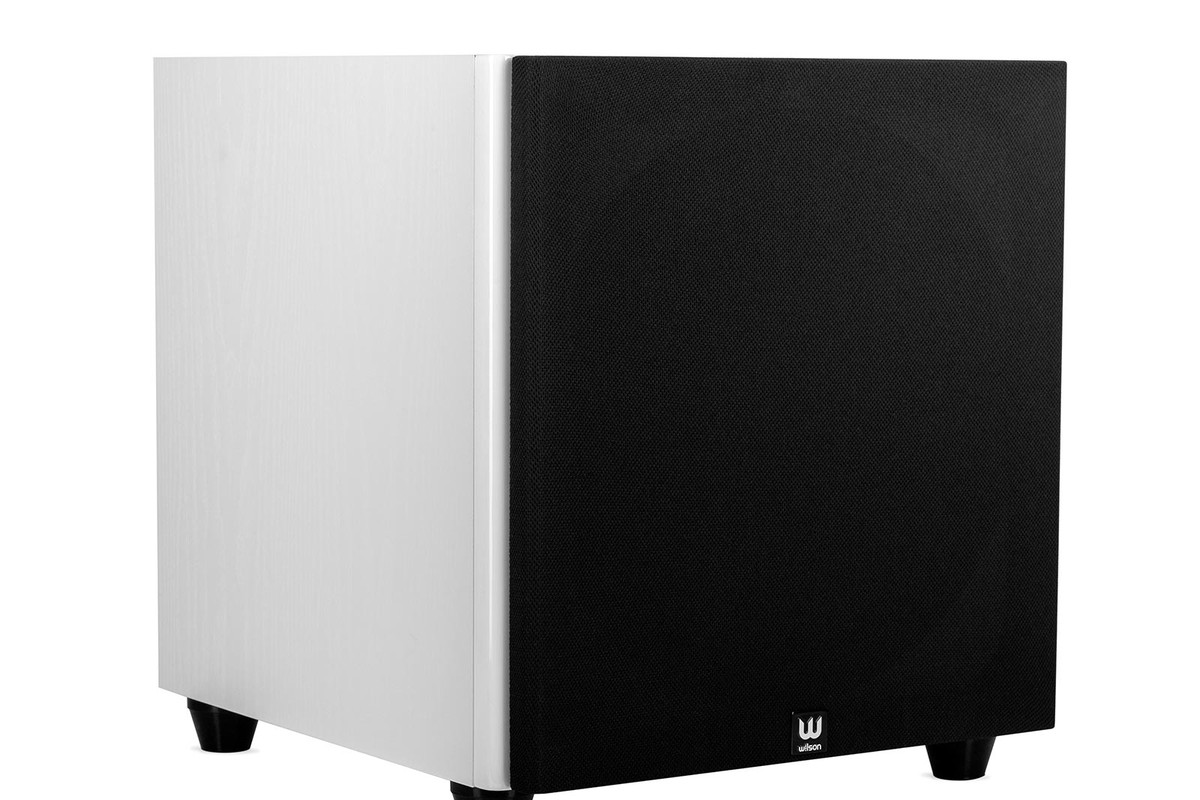 White subwoofer from three quarters, front face covered by its black grille