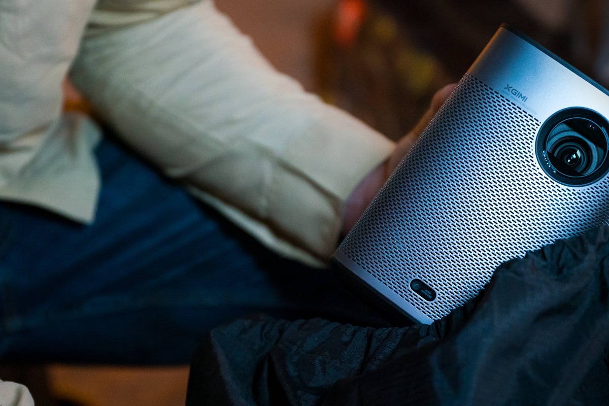XGIMI Halo+ held in one hand, lens and metal grille