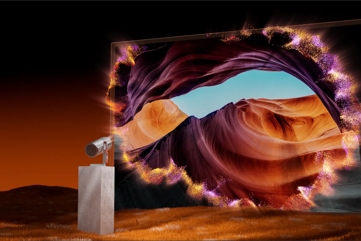 Small projector on a base projecting a purple and orange canyon onto a large screen