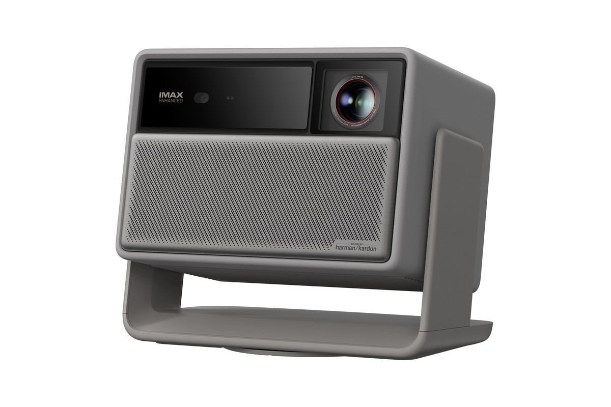 Grey projector in three-quarter view, black lens strip above the speaker grille