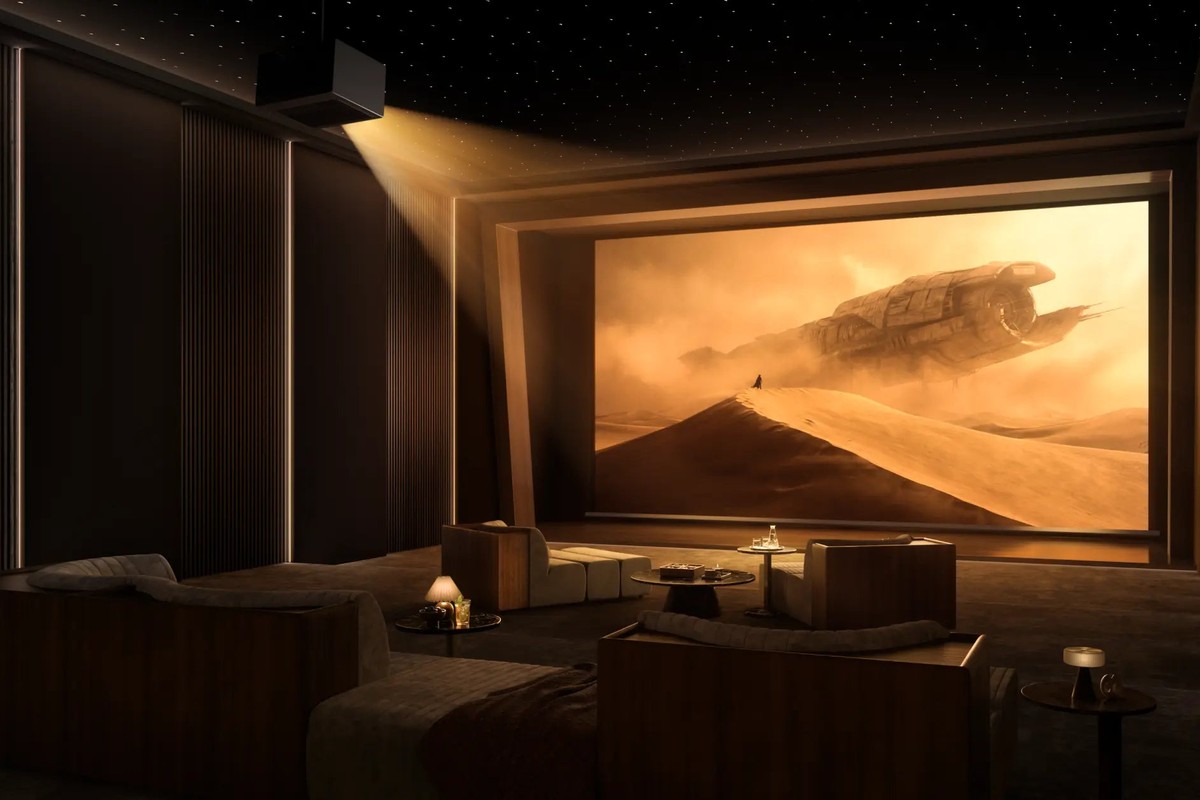 Private cinema room in darkness, ceiling-mounted projector, desert scene on a large screen
