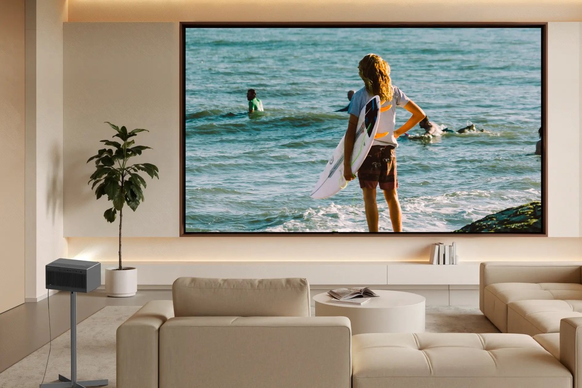 XGIMI TITAN Noir Pro on a stand in a bright living room, surfing scene on the screen facing the sofa