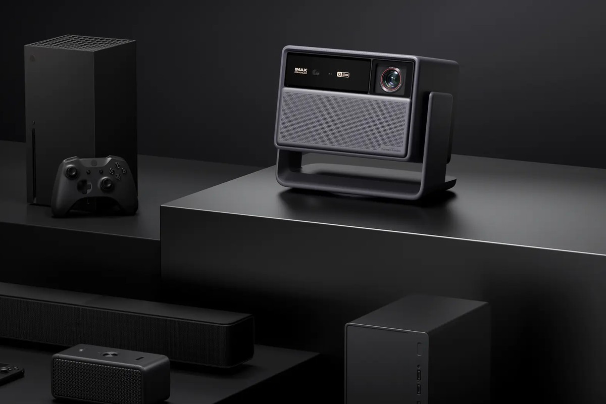 Proiettore su un supporto accanto a una console, un controller e una soundbar