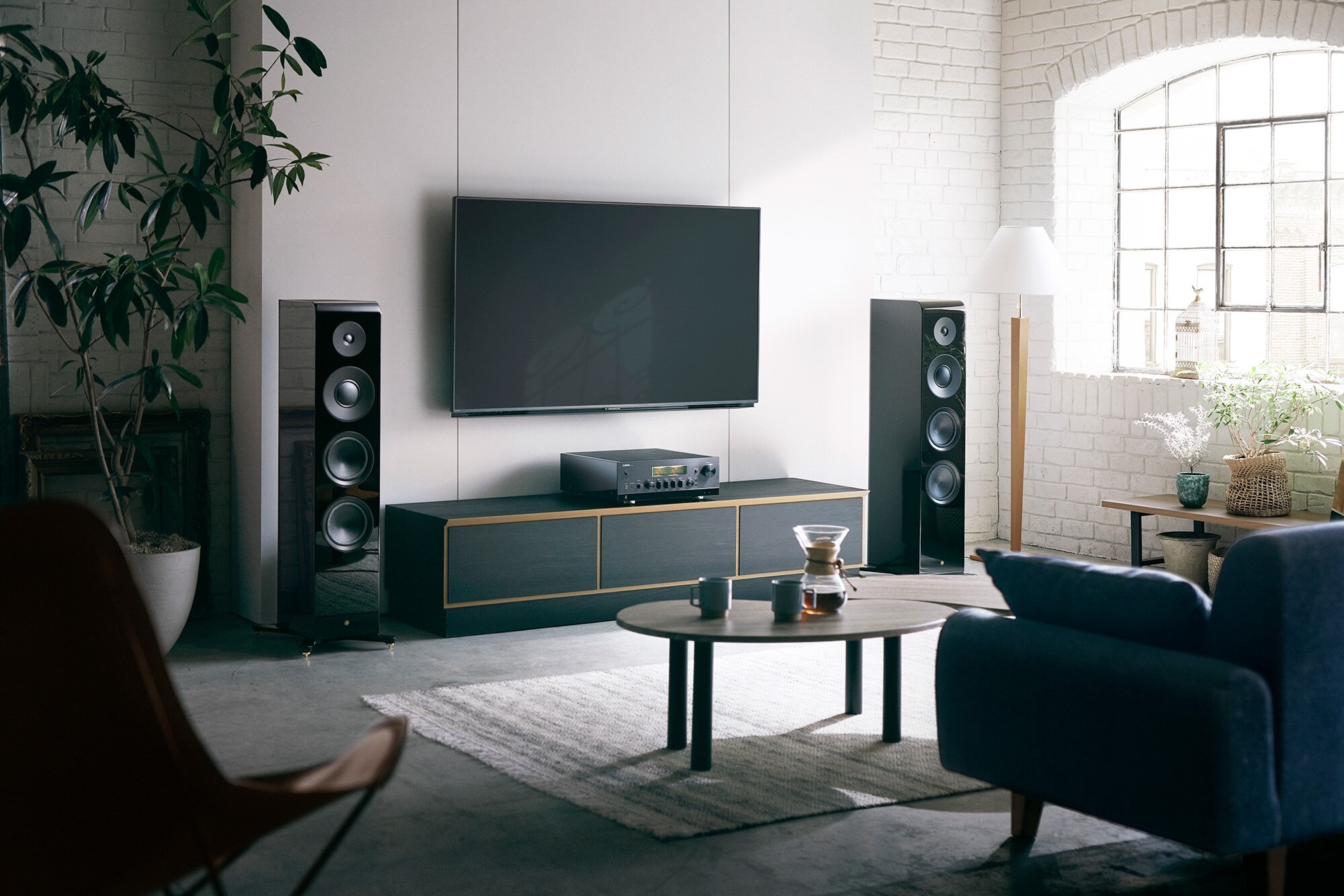 Ampli-tuner réseau noir dans un salon, téléviseur et colonnes de part et d'autre