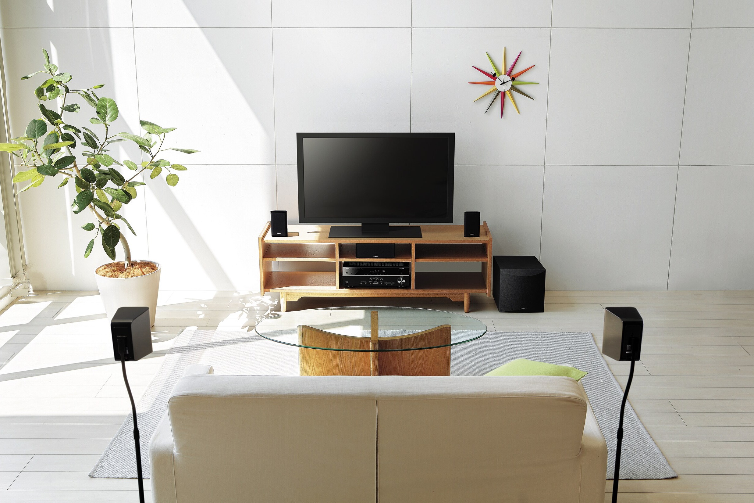 Ensemble home cinéma installé dans un salon clair autour d'un téléviseur