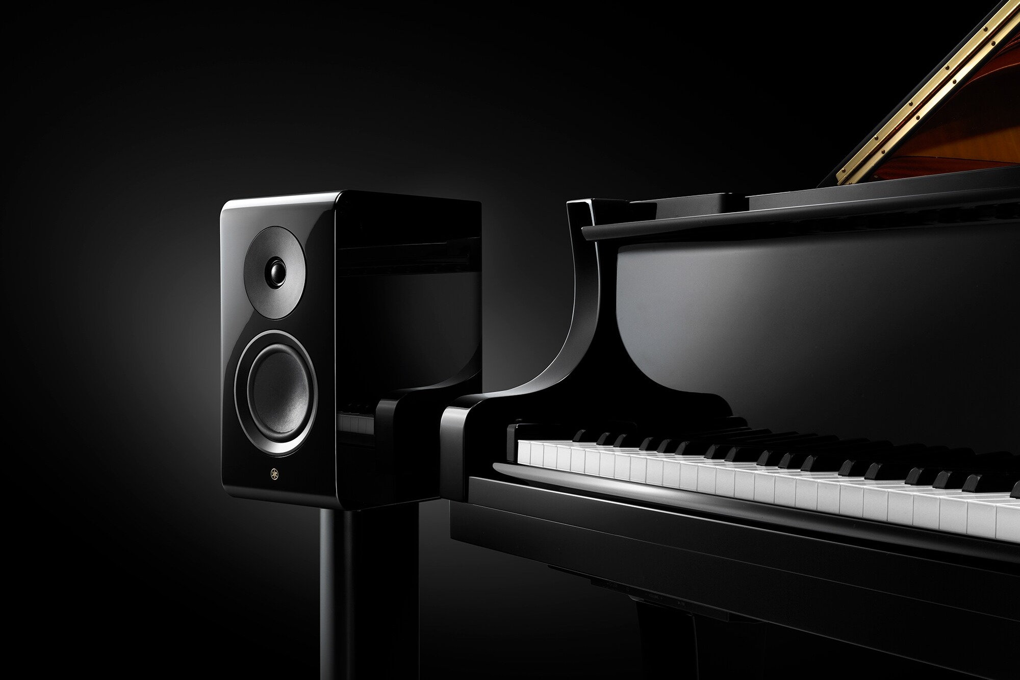 Yamaha NS-600A Lautsprecher auf Ständer neben einem Flügel