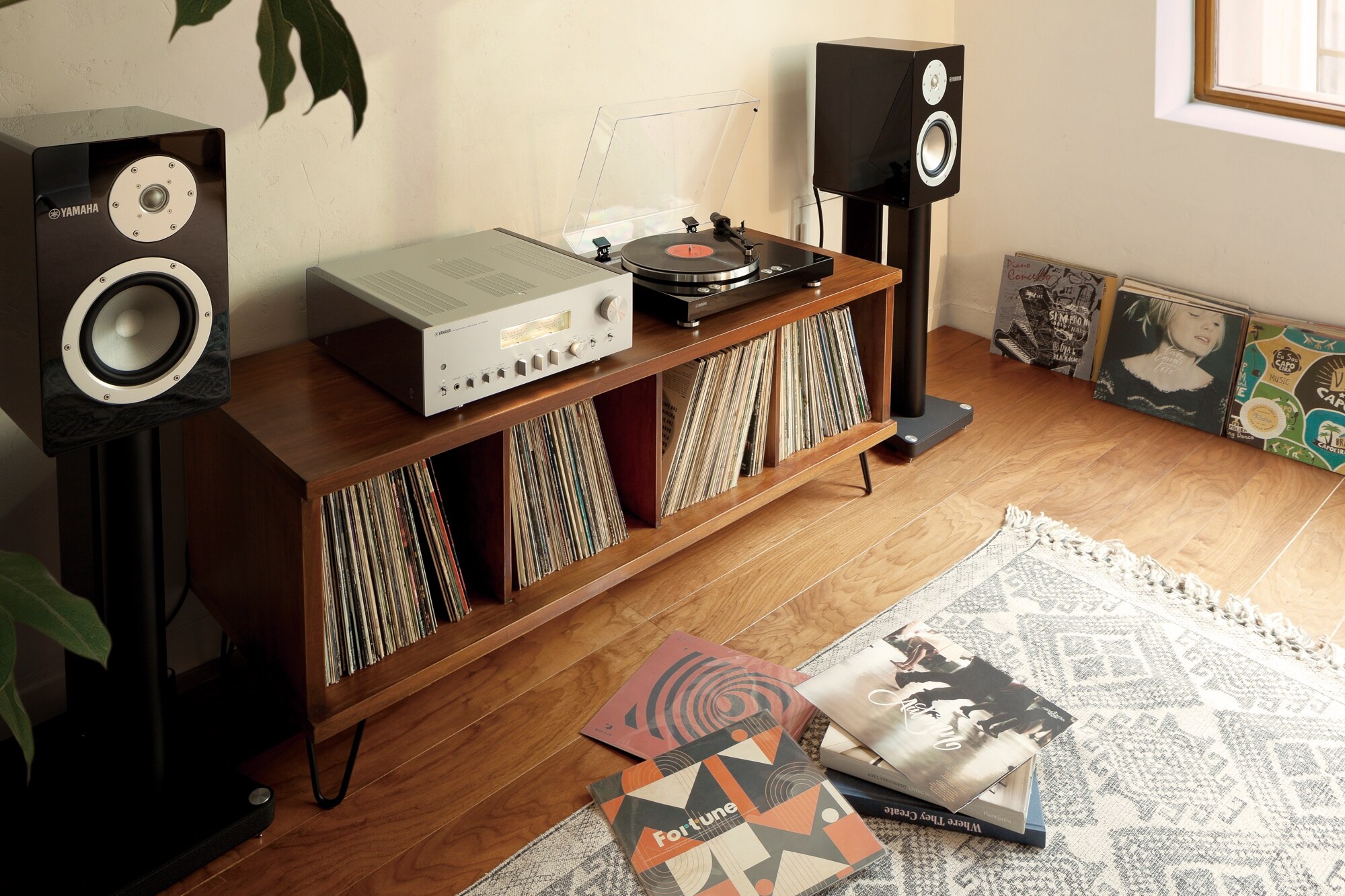 Amplifier on a low sideboard, speakers and a turntable around it