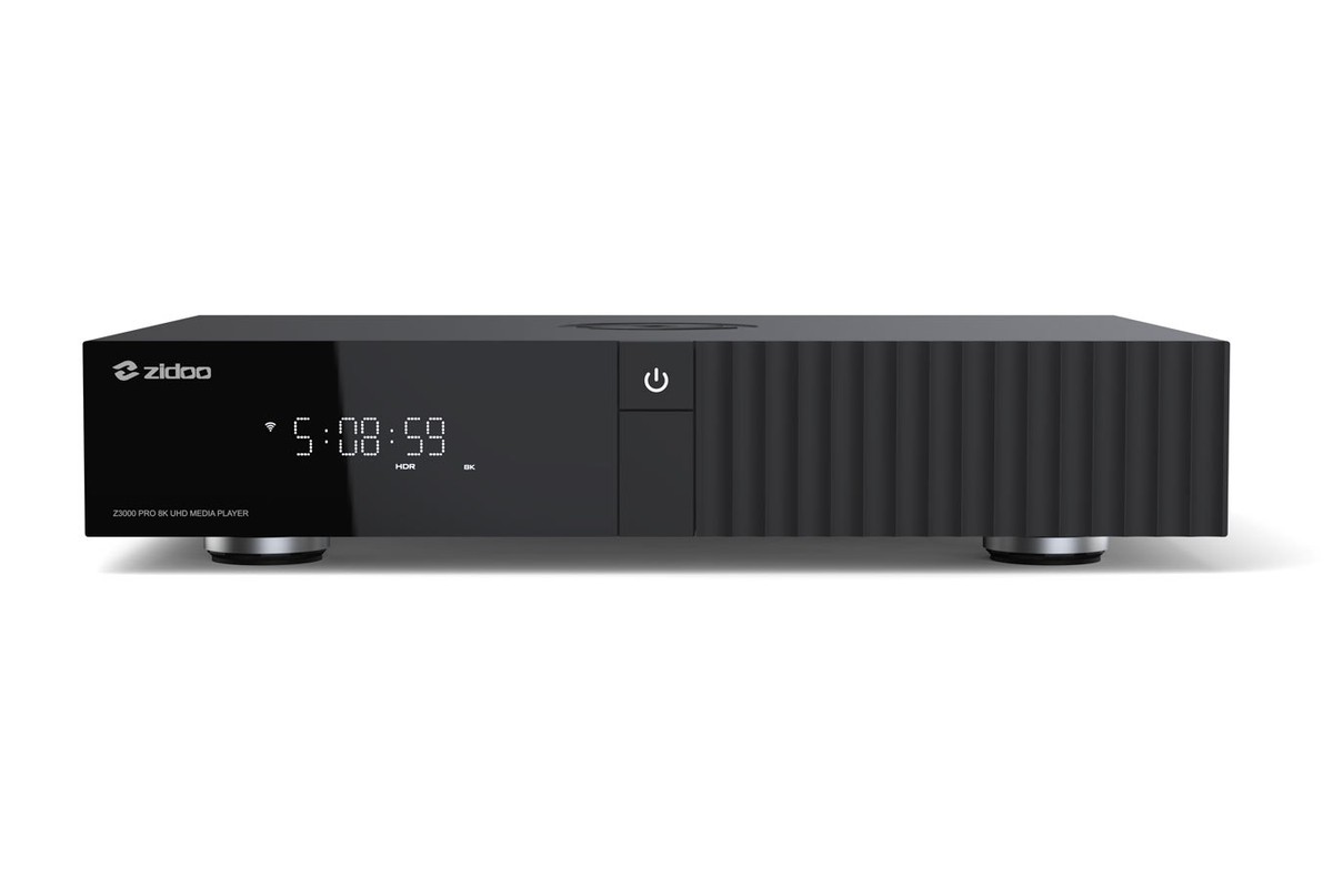 Flat black media player seen from the front, LED display and ribbed side section